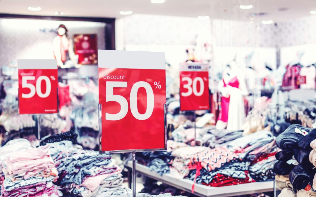 Tables of clothes with signs advertising Black Friday sales.